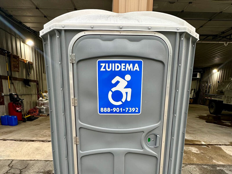 A Zuidema gray porta potty rented for a garage in New York and New Jersey
